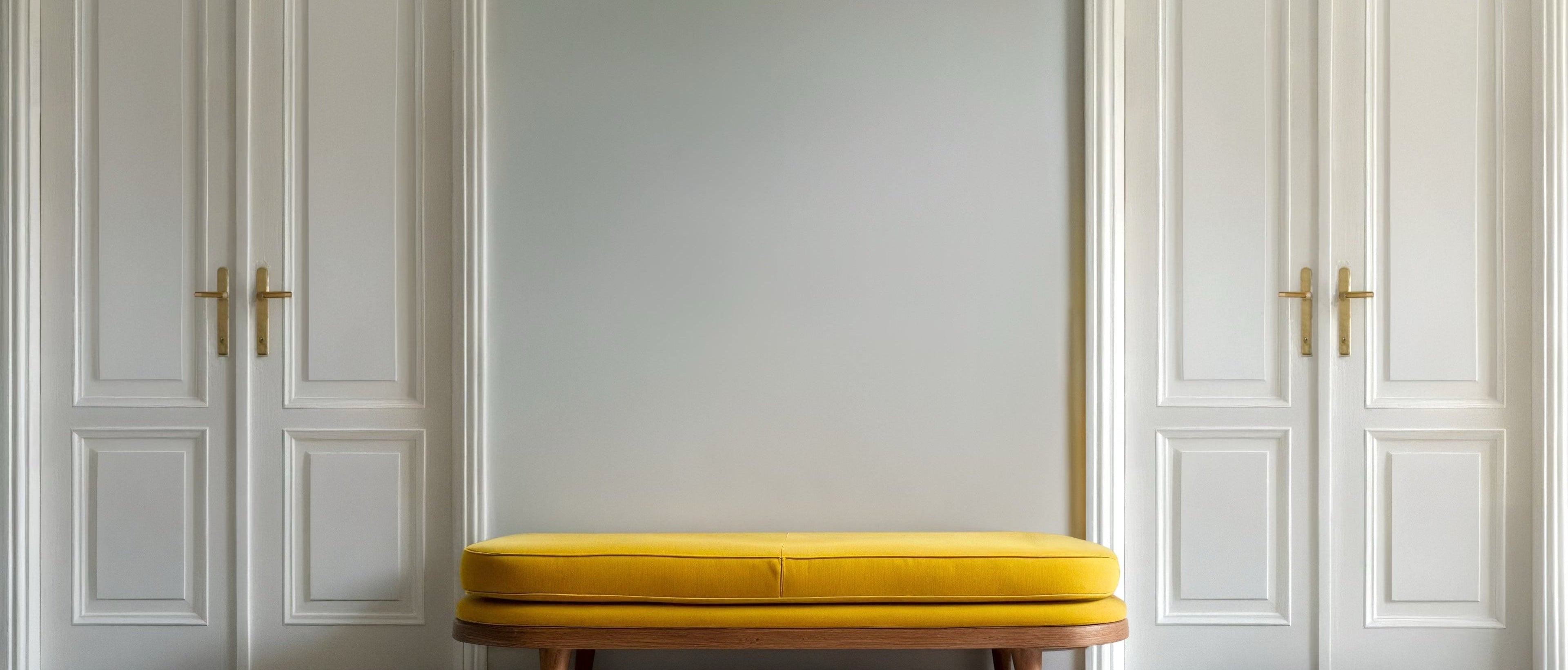 Art Collections: Yellow bench in a room with white paneled walls and gold door handles.