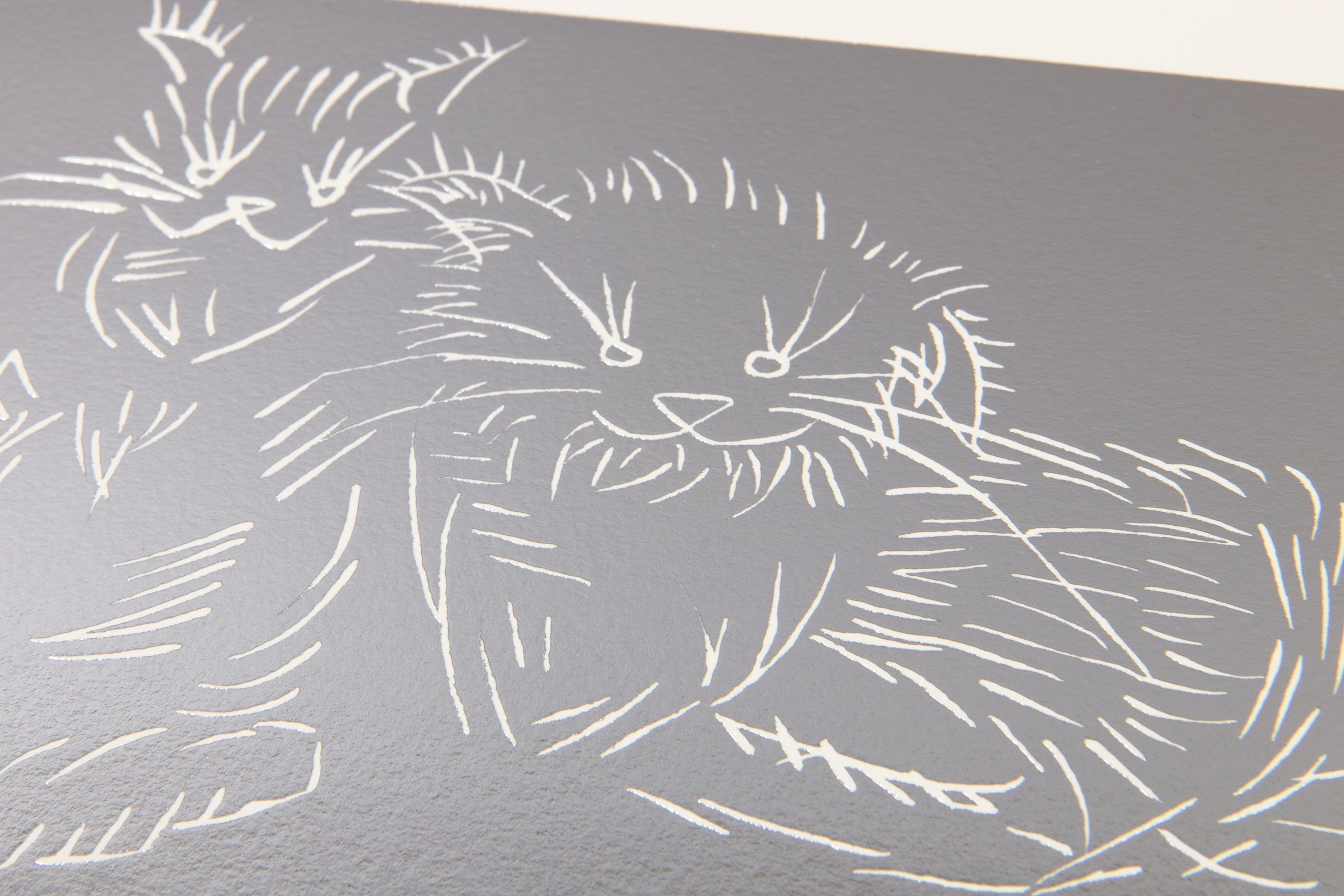 Detail of Ai Weiwei Cats Silver foil artwork highlighting engraved cat figures and reflective texture